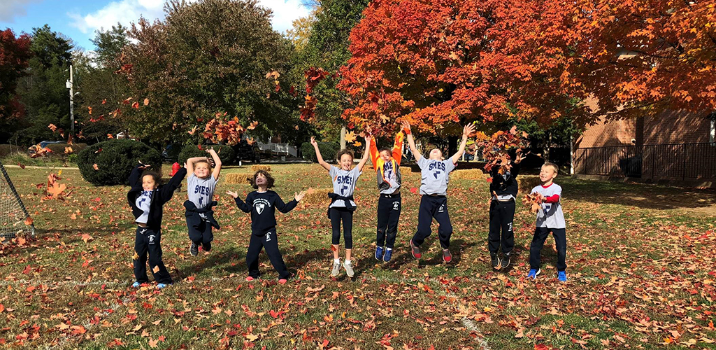FactsataGlance Episcopal School Kids Playing in Fall Leaves